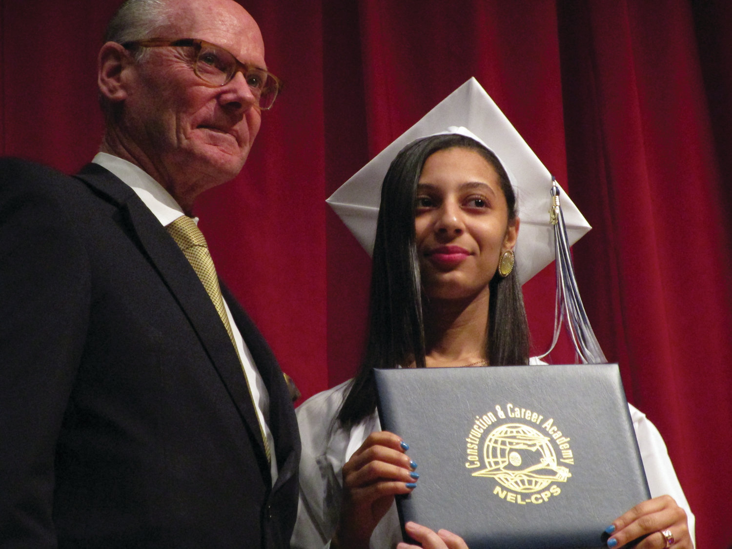 MOMENT OF ACHIEVEMENT: Dennis Curran, executive director of the NEL/CPS Construction & Career Academy, presents a diploma to Kristal Brown, the "top scholar" in the academy's class of 2019.